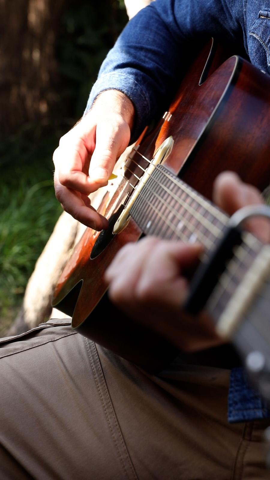 Close view of an acoustic guitarist performing